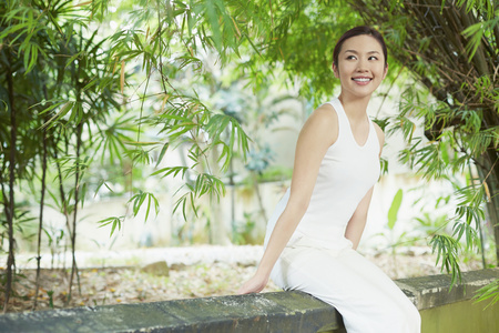 A young woman sitting on the wallの写真素材
