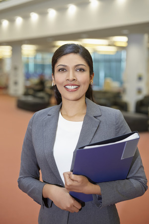 Cheerful businesswoman holding filesの写真素材