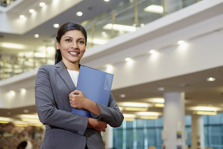 Cheerful businesswoman holding filesの写真素材