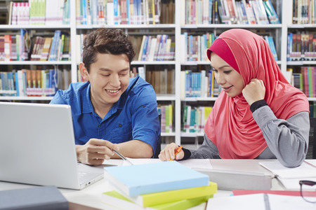 Two students studying together in libraryの写真素材
