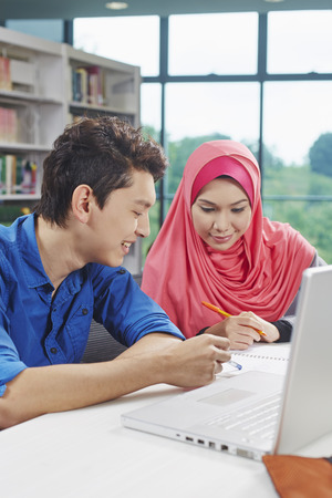 Two students studying together in libraryの写真素材