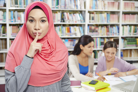 A student hand gesturing to sign to be quietの写真素材
