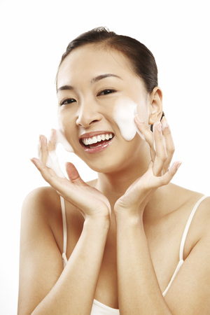 Woman using facial foamの写真素材