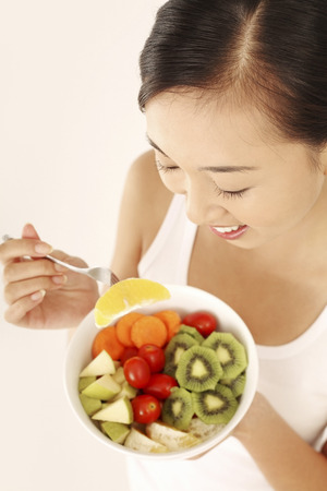 Woman enjoying a fruit and vegetable saladの写真素材
