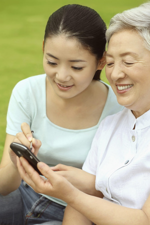 Senior woman showing woman text message on her phoneの写真素材