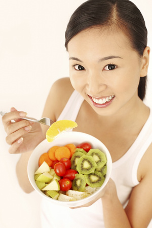 Woman enjoying a fruit and vegetable saladの写真素材