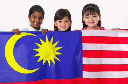 Young Malay, Chinese and Indian girls holding Malaysian flagの写真素材