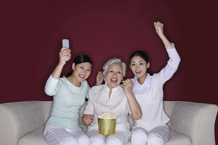 Three women watching television togetherの写真素材
