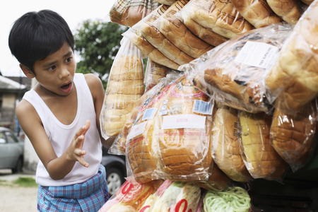 Boy choosing bread from breadman's motorcycleの写真素材