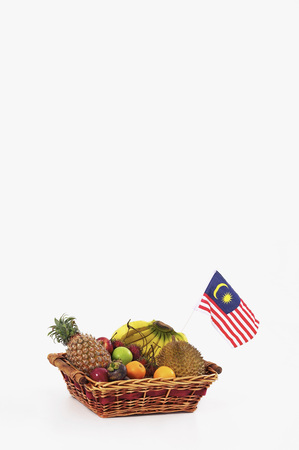 Basket of tropical fruits and Malaysian flag on white backgroundの写真素材