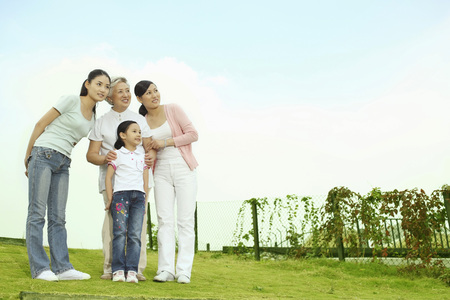 Three women and girl smiling and looking awayの写真素材