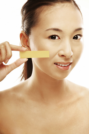 Woman holding a skin tone pallette over her cheekの写真素材
