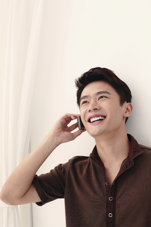 Man smiling while talking on the phoneの写真素材
