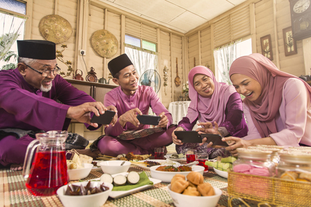 Muslim family taking pictures of food during the Eid al-Fitrの写真素材