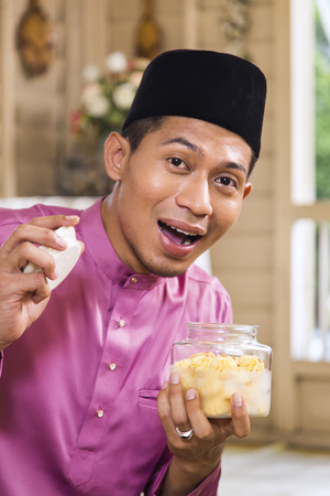 Muslim man holding traditional Malay cookieの写真素材