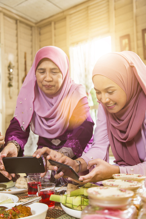 Muslim women taking pictures of food during the Eid al-Fitrの写真素材