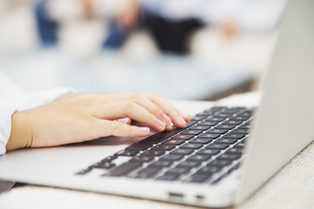 Hands typing on laptop keyboard
