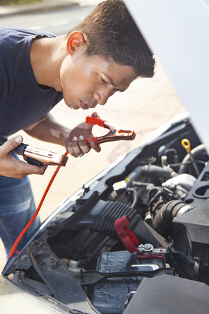 Man using battery jumper cables on a dead batteryの写真素材