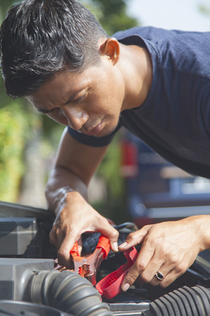 Man using battery jumper cables on a dead batteryの写真素材