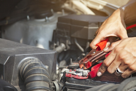 Man using battery jumper cables on a dead battery