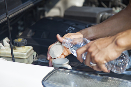 Man refilling wiper tankの写真素材