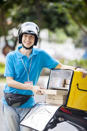 Food delivery man taking food from a bagの写真素材