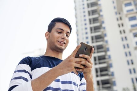 Young man texting on the phoneの写真素材