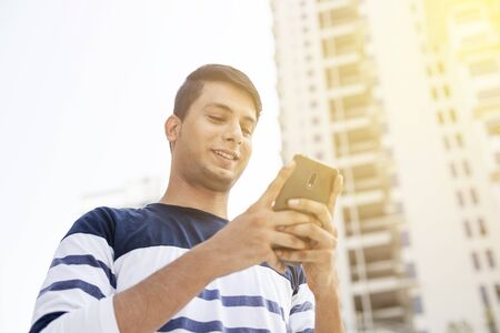 Young man texting on the phoneの写真素材