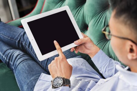 Man using a digital tablet on a couch