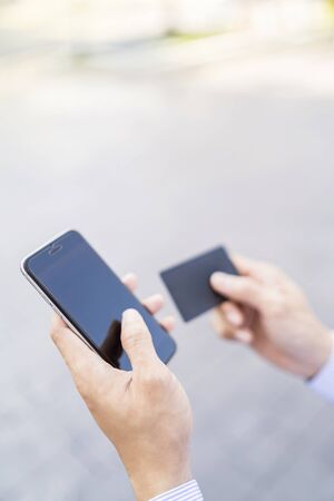 Man holding a phone and cardの写真素材