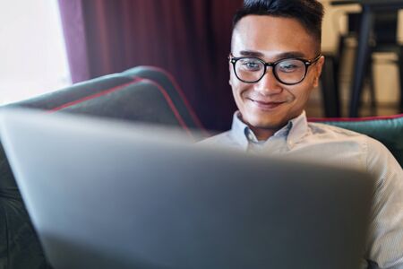 Man using a digital tablet on a couchの写真素材