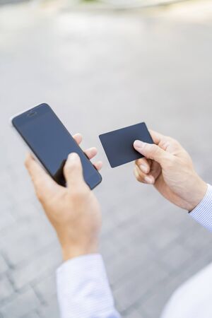 Man holding a phone and cardの写真素材
