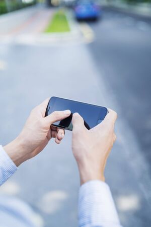 Man playing game on mobile phoneの写真素材