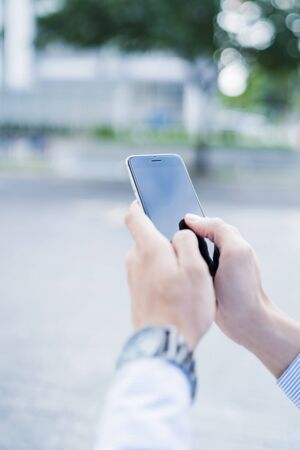 Man using mobile phone outdoorsの写真素材