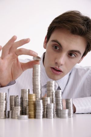 Man carefully stacking coins