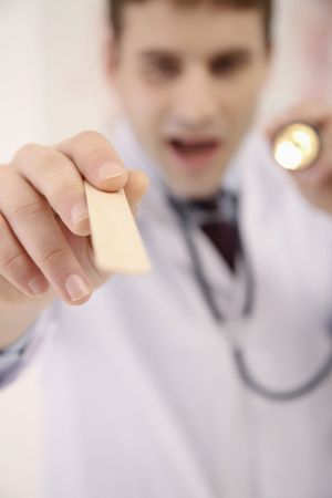 Doctor holding flashlight and tongue depressorの写真素材