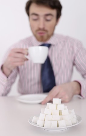 Man enjoying a cup of coffee, focus on sugar cubesの写真素材
