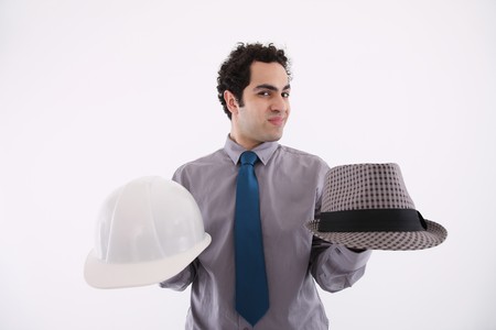 Businessman holding fedora and safety helmetの写真素材
