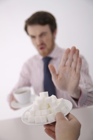 Man showing hand gesture saying "No" at the offer of sugar cubesの写真素材