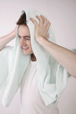 Man wiping his hair with towelの写真素材