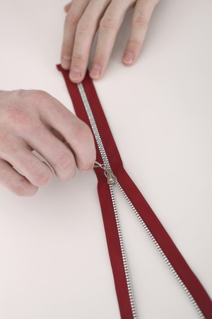 Man zipping up zipper on the tableの写真素材