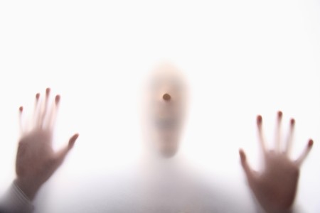 Silhouette of a man behind transparent paperの写真素材