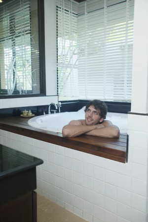 Man daydreaming while in bubble bathの写真素材