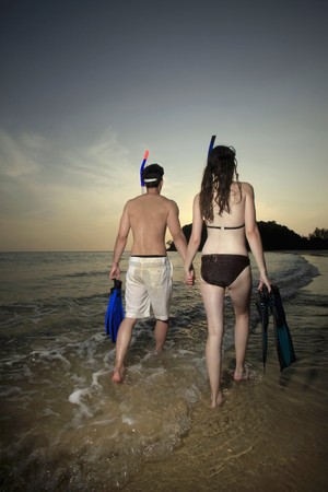 Man and woman carrying snorkeling gearの写真素材