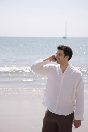 Man talking on the phone at the beachの写真素材