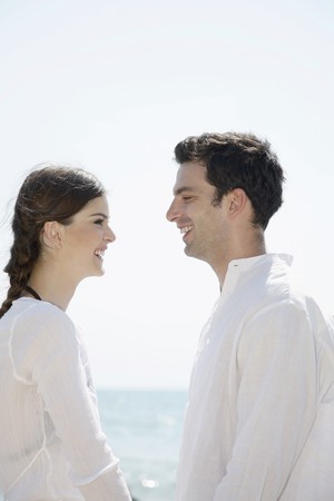 Man and woman smiling while looking at each otherの写真素材