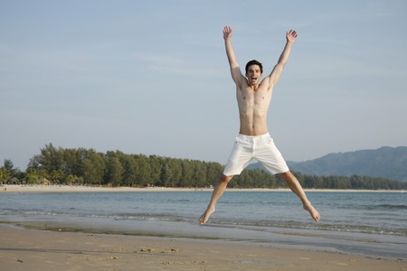 Man jumping jacks on beachの写真素材