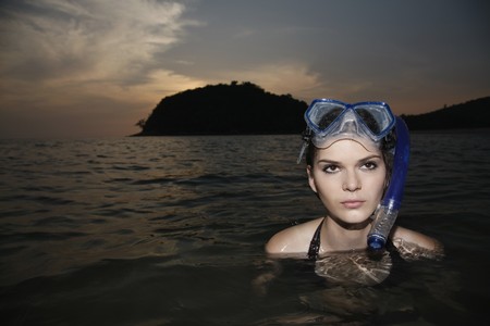 Woman with scuba mask in seaの写真素材