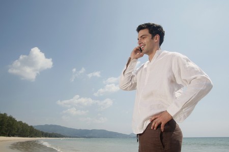 Man talking on the phone at the beachの写真素材