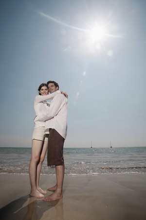 Man and woman embracing on the beachの写真素材